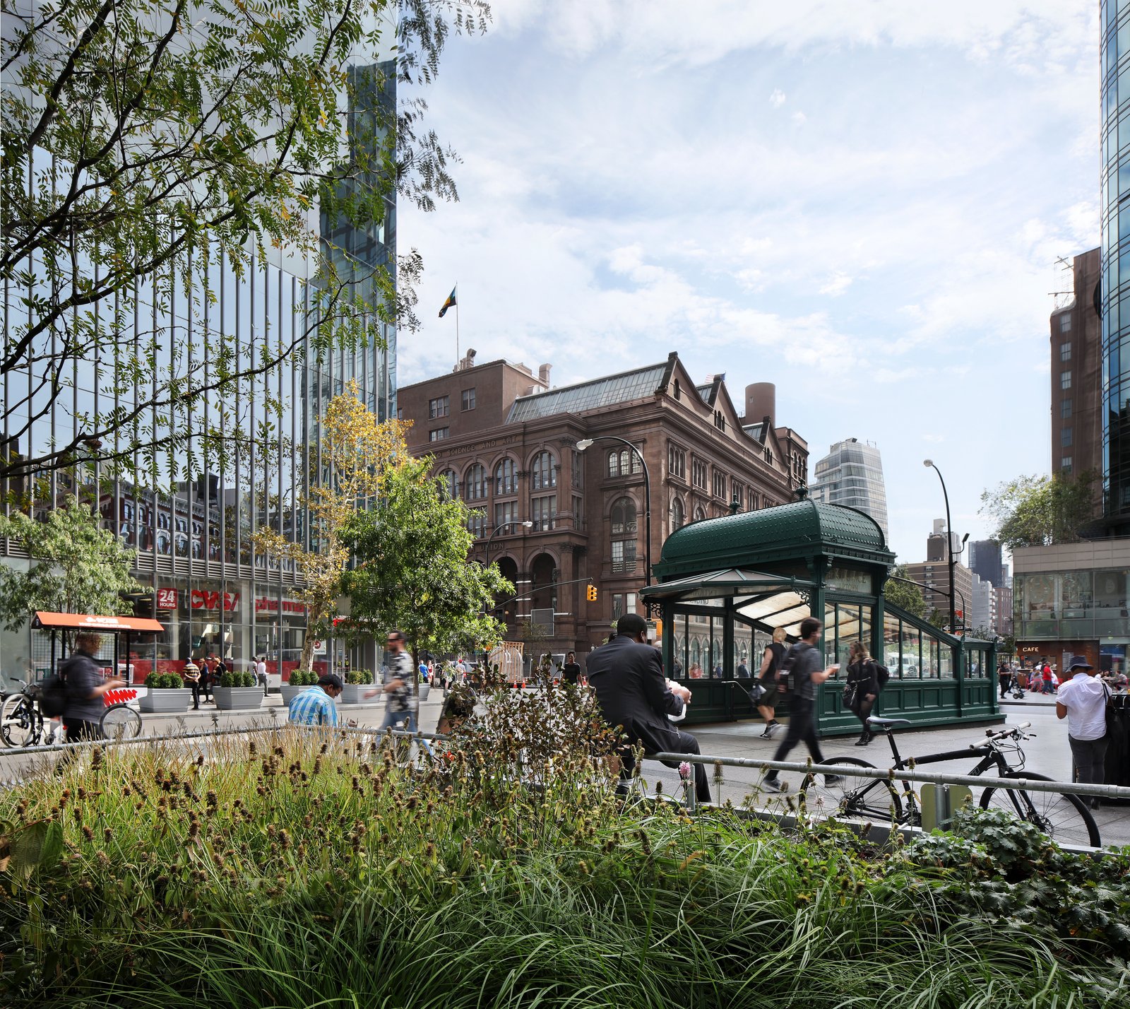 A historic subway kiosk surrounded by greenery, pedestrians, and urban buildings.