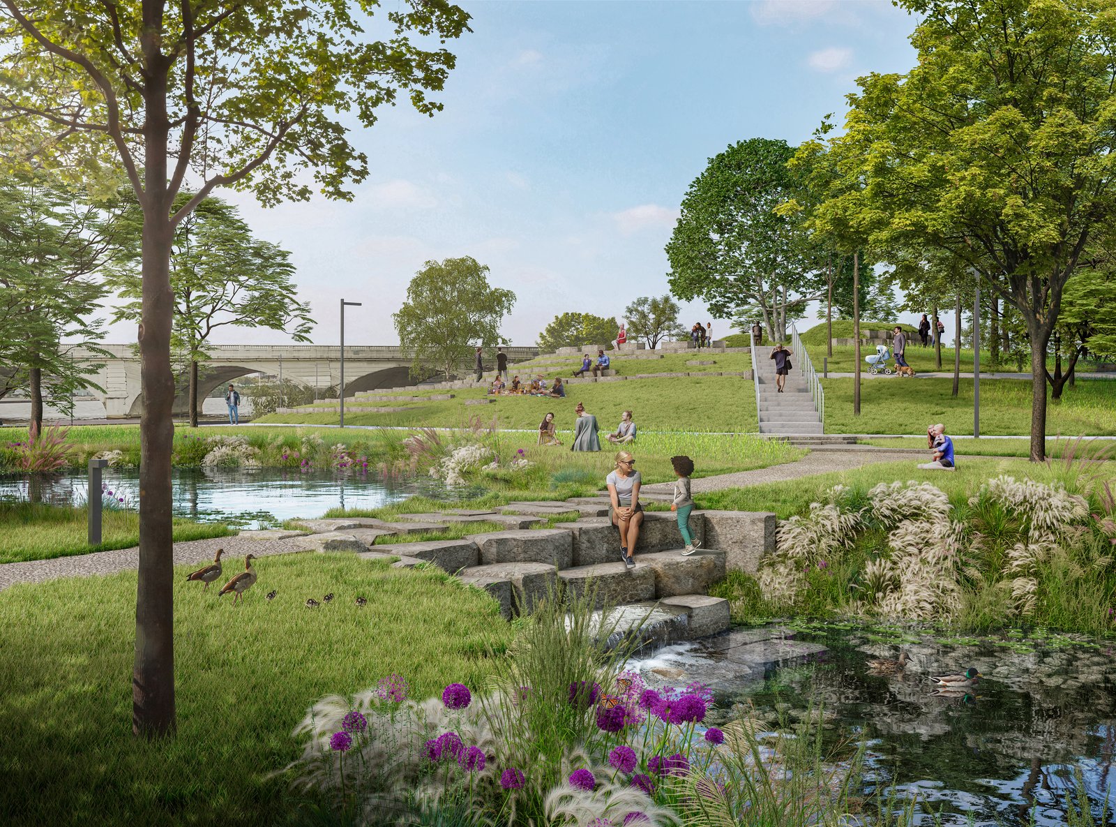 View of International Hill at Glass City Riverwalk with people enjoying green space and a pond.