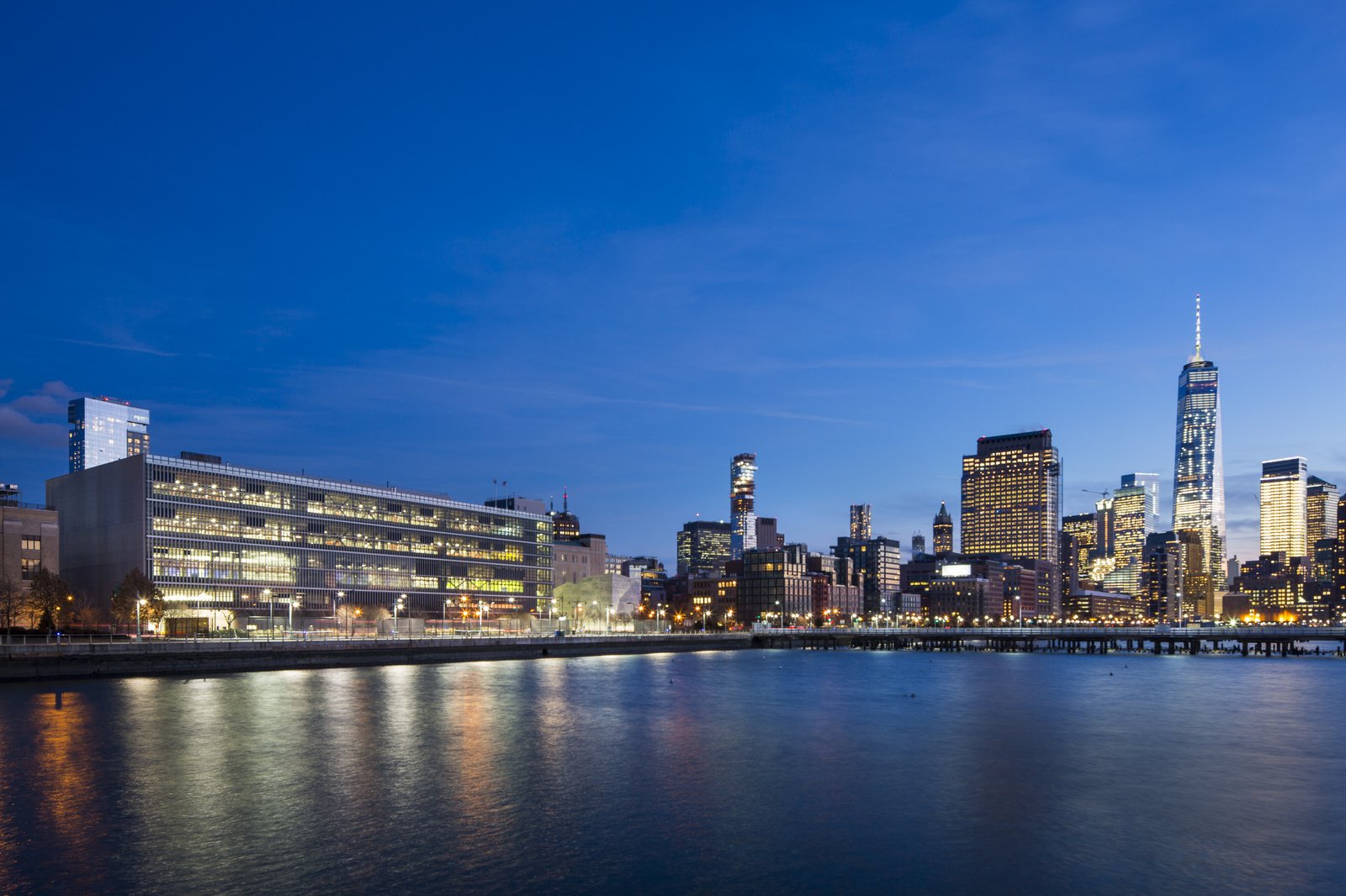 Evening view of DSNY garage and Salt Shed with Manhattan skyline in the background.