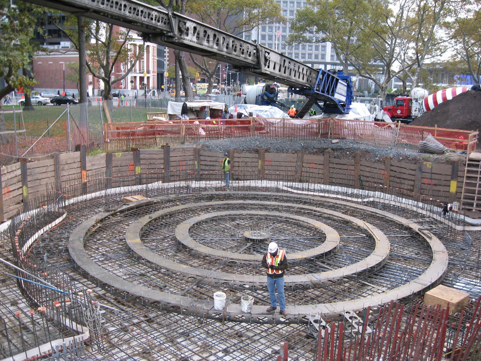 Circular foundation under construction with rebar and concrete layers.