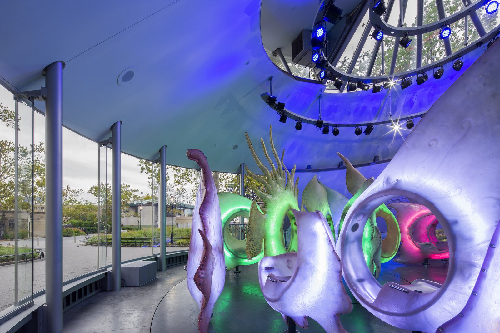 Interior view of SeaGlass Carousel with illuminated fish sculptures and glass walls.