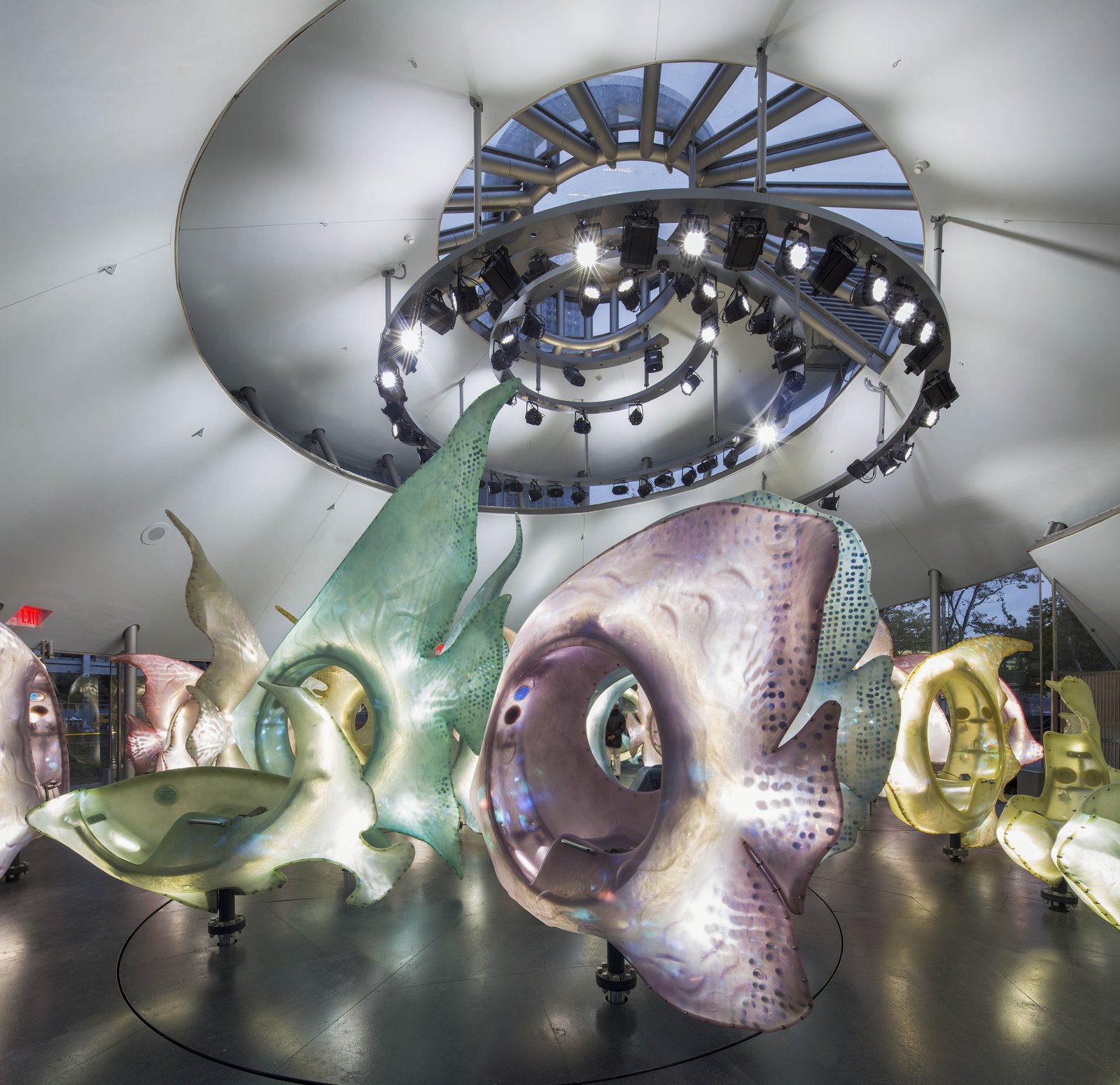 Interior of SeaGlass Carousel with illuminated fish seats under circular lighting.