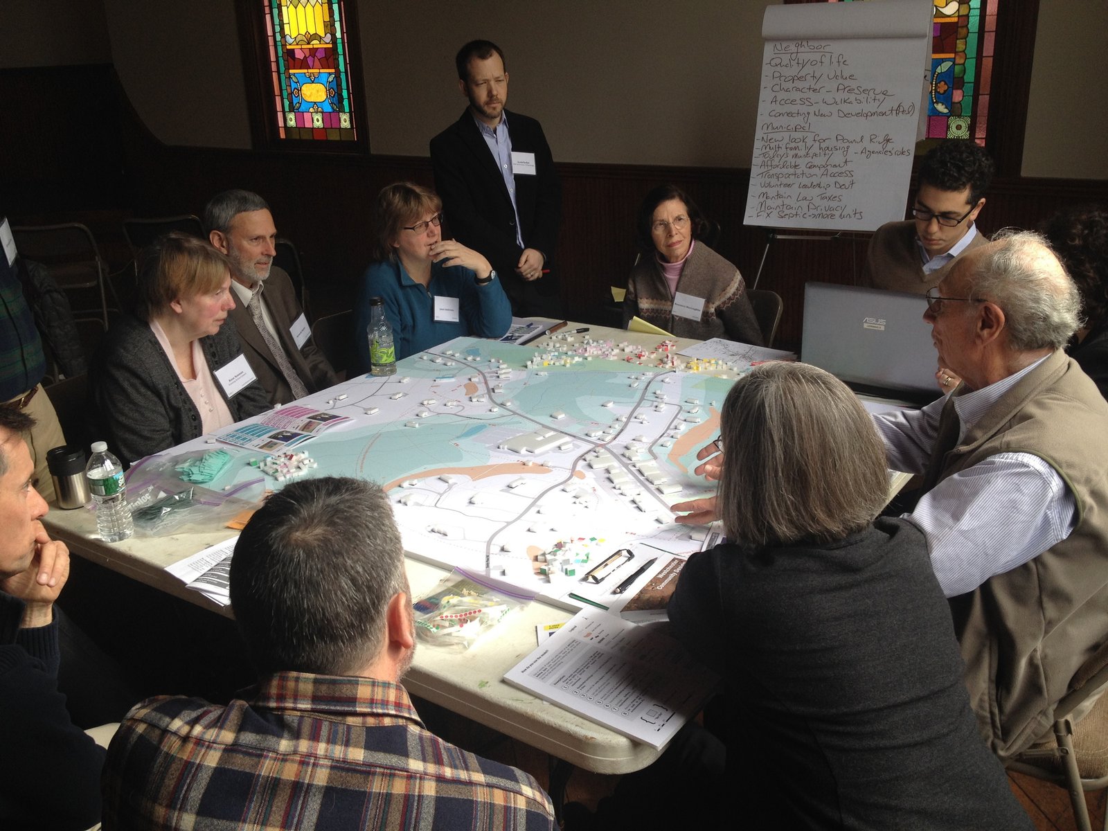 Community members gather around a large planning map during a collaborative workshop.