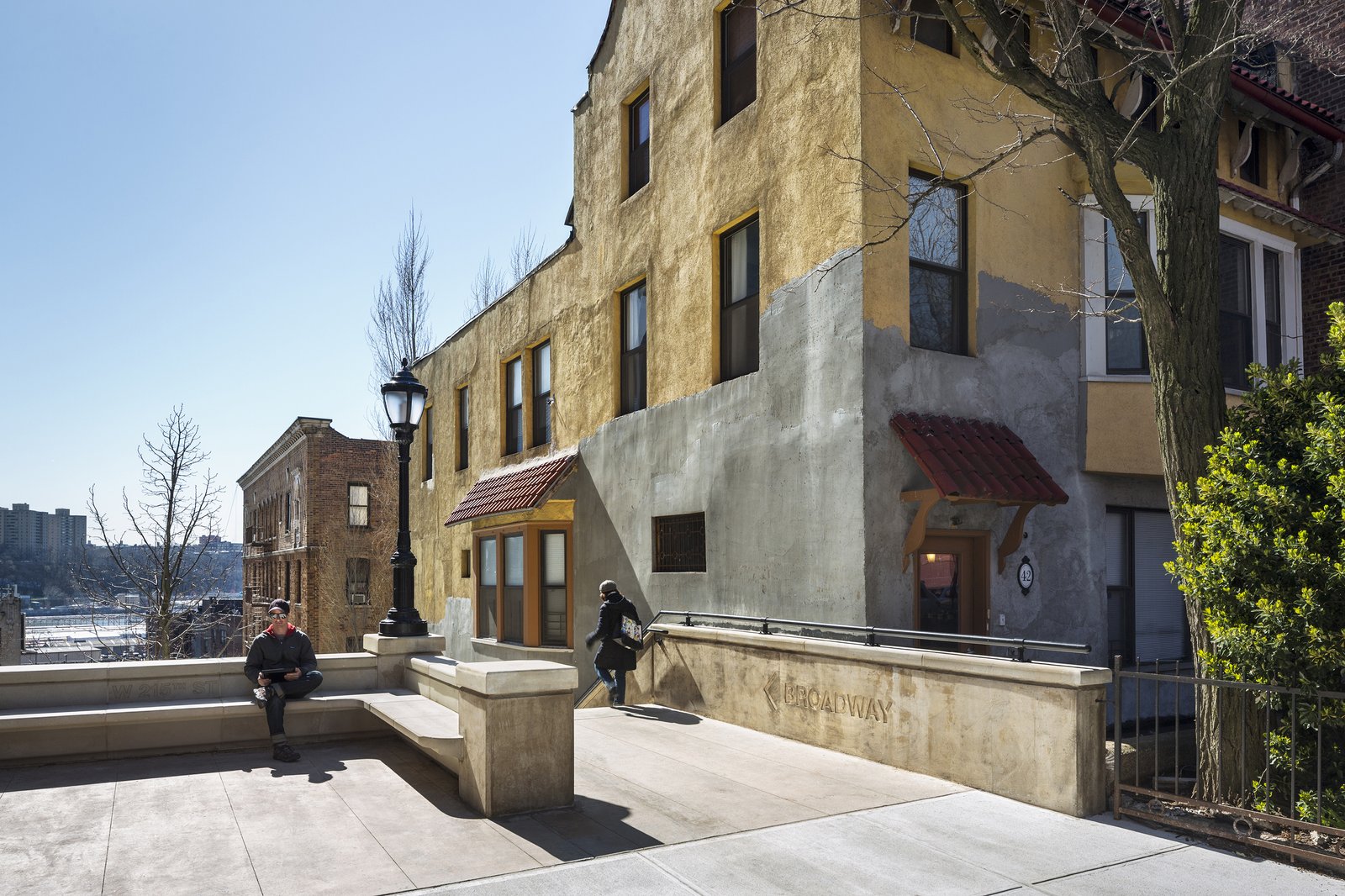 The top landing of the steps with benches, lampposts, and a yellow stucco building nearby.