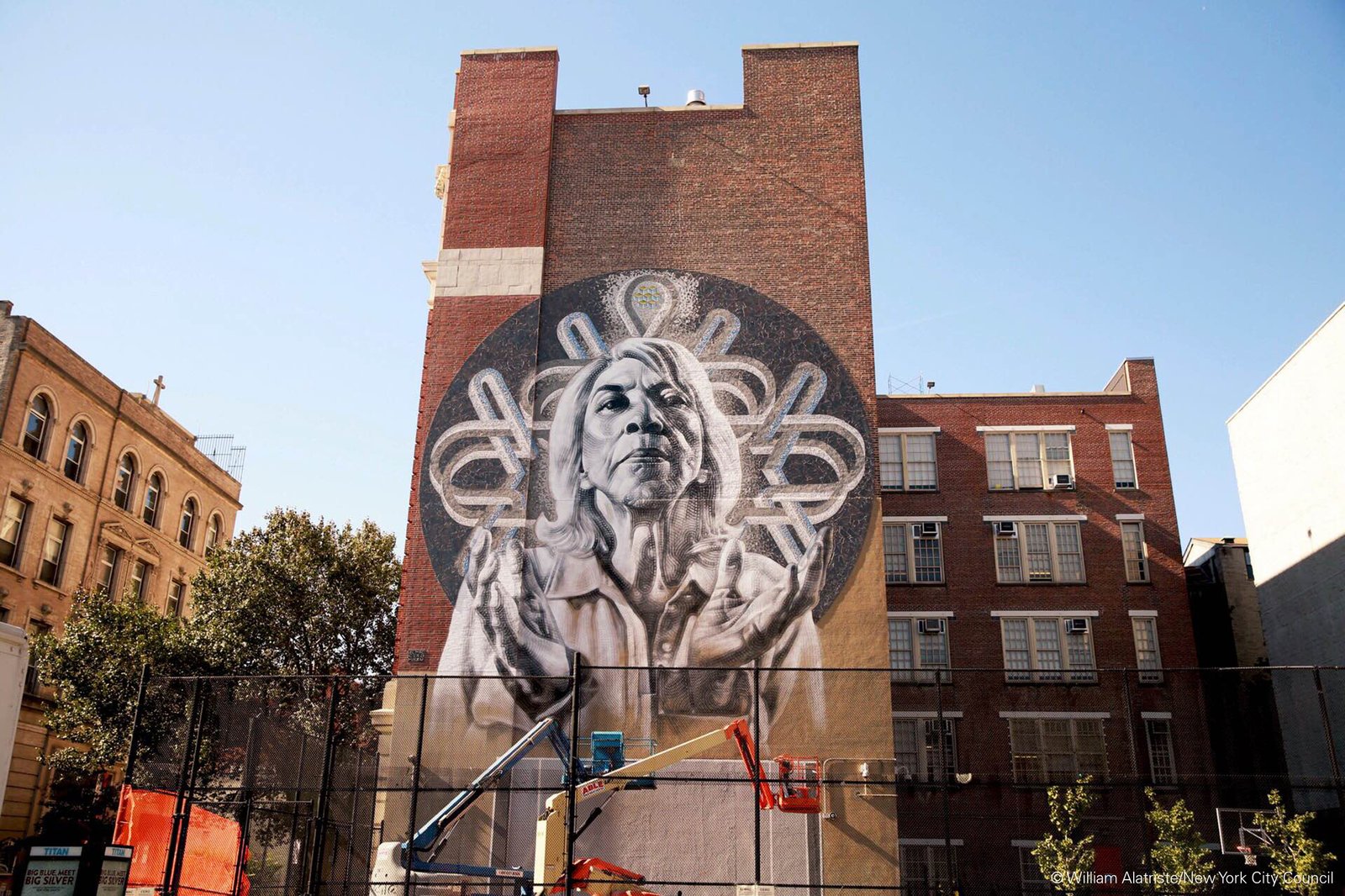 Large mural of a woman on a brick building in East Harlem.