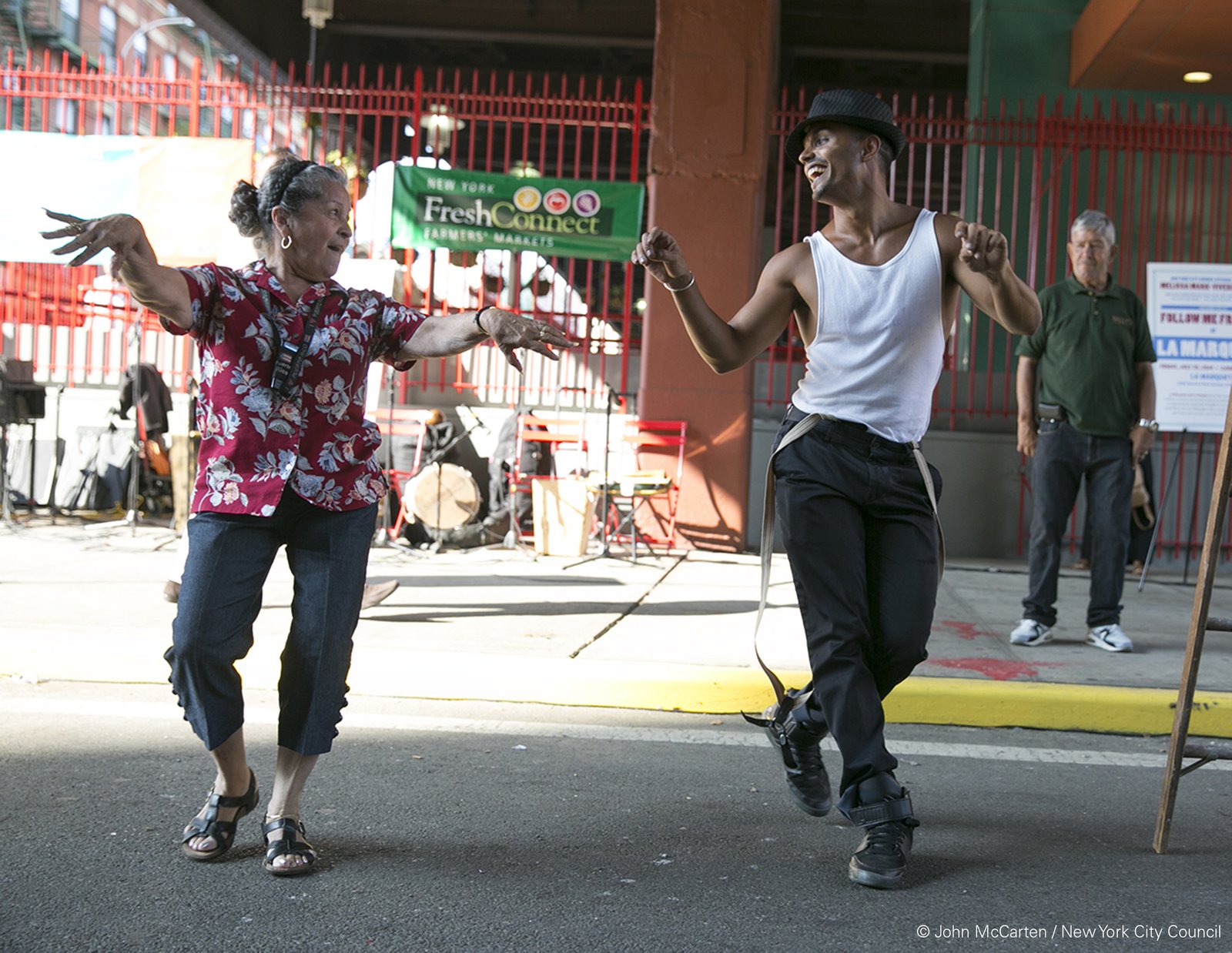 Two people dancing joyfully in East Harlem.