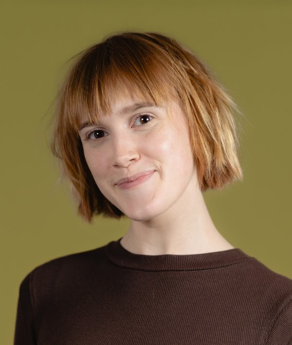 Headshot of Ella Erwin against a green background.