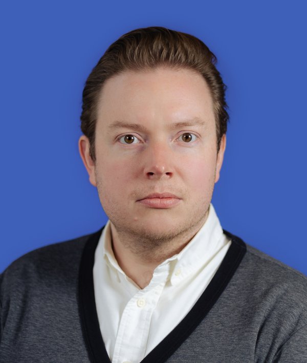 Headshot of Peter Eichberger against a blue background.