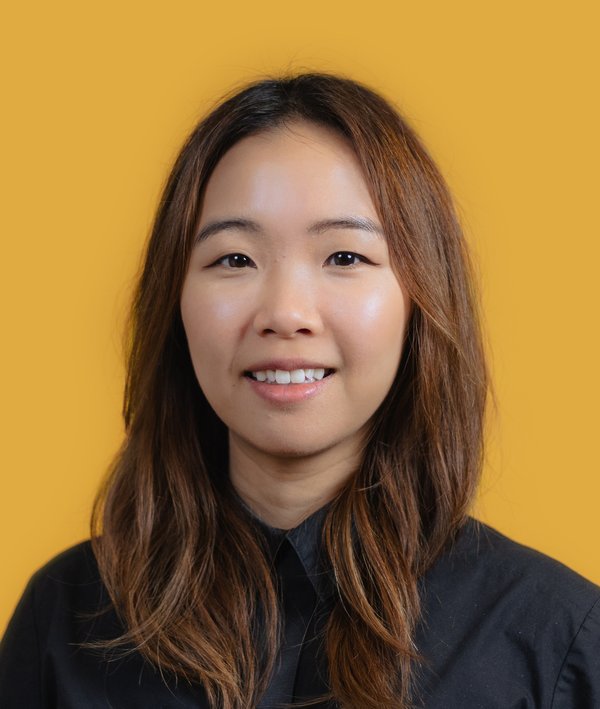 Headshot of Serena Ching in dark shirt against a yellow background.