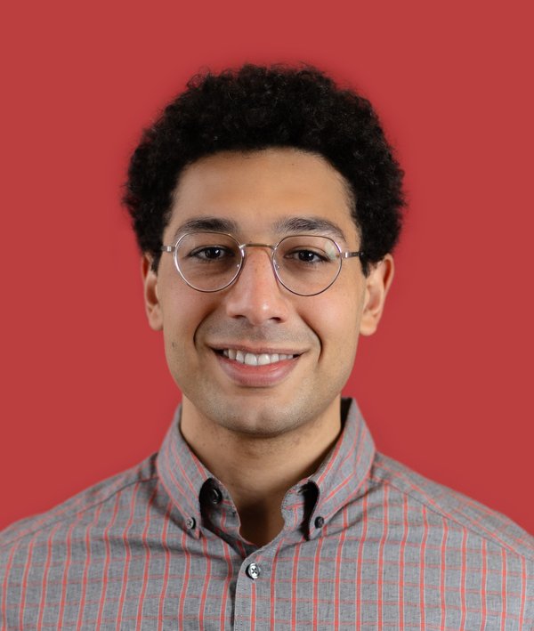 Headshot of Bahij Chancey against a red backdrop.