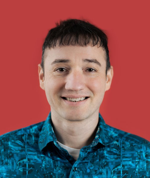 Headshot of Richard Jolta against a red background.