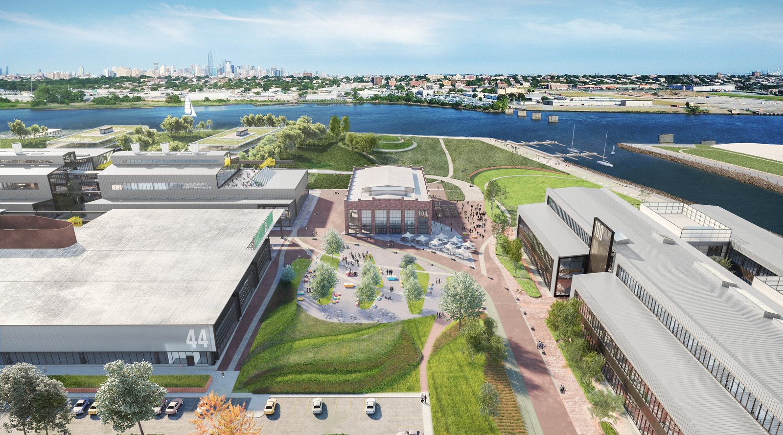 Aerial rendering of waterfront campus with restored industrial buildings, landscaped paths, and Manhattan skyline.