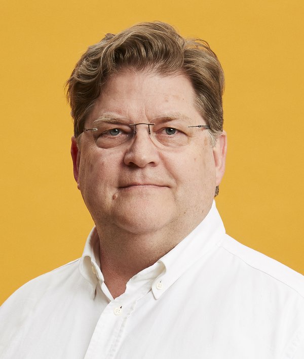 Headshot of Layng Pew with a white shirt and yellow background.