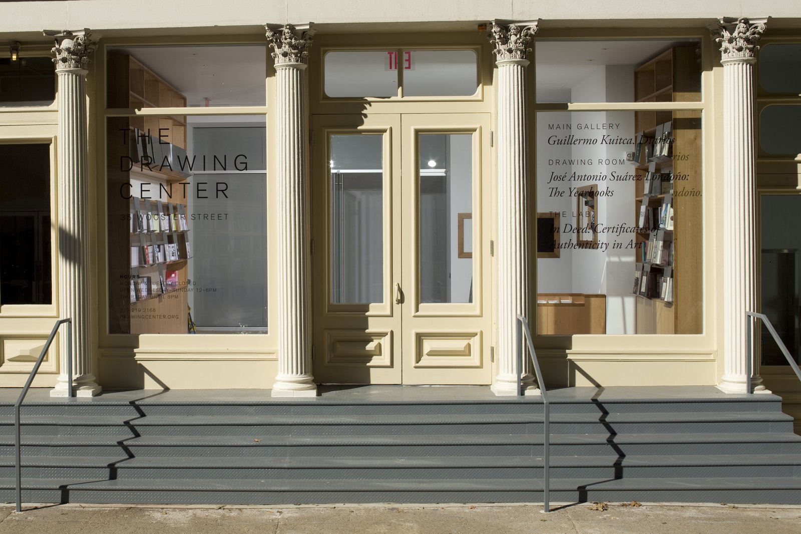 Storefront of The Drawing Center with cream-colored Corinthian columns, large windows, and stepped entrance.