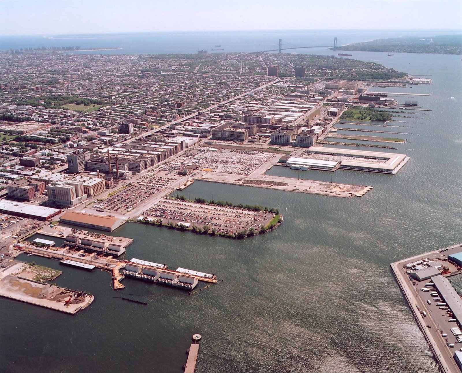 Aerial view of industrial waterfront complex and surrounding urban area.