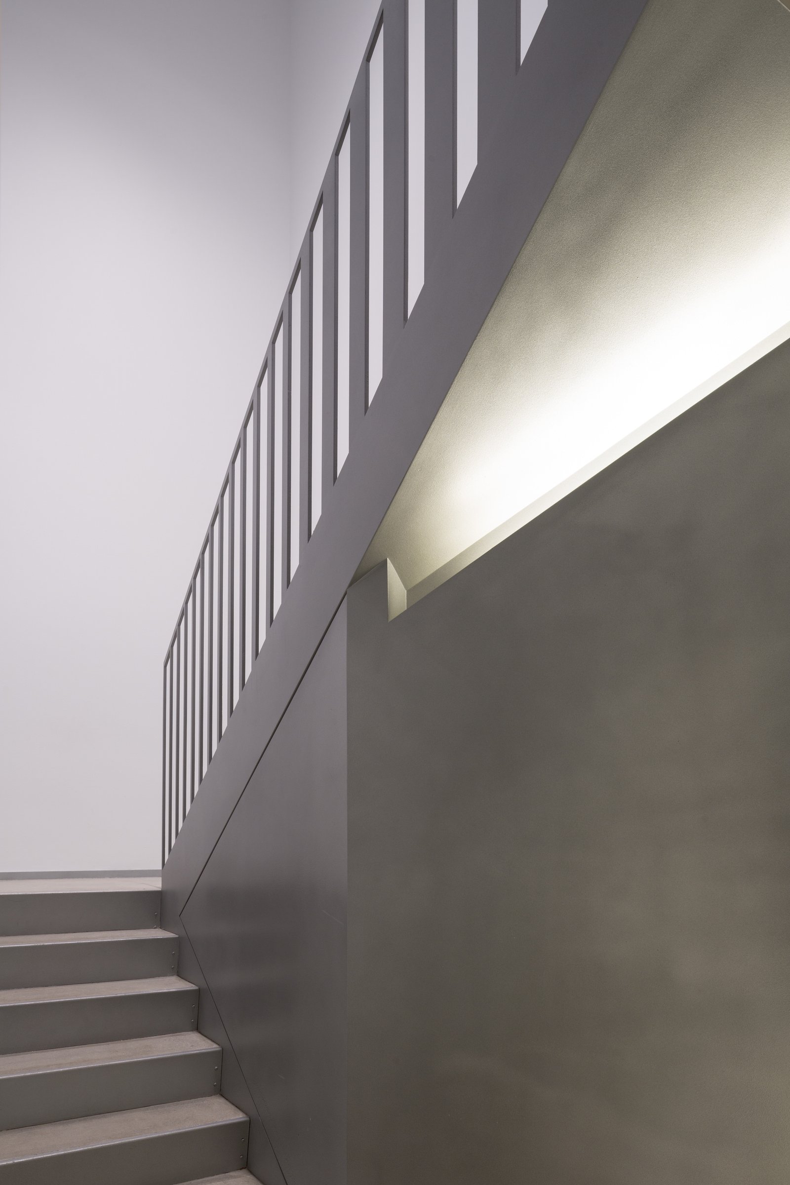 Minimalist staircase with sleek railing and soft lighting.