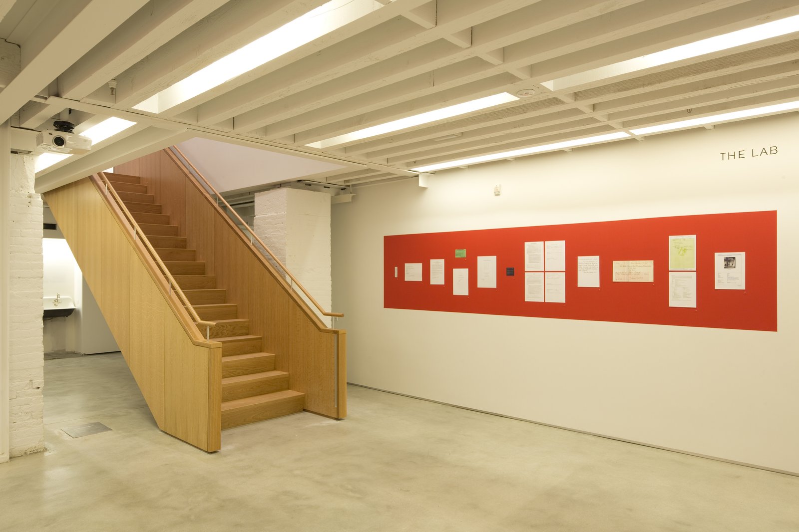 Lower-level lab area with staircase and red bulletin board.