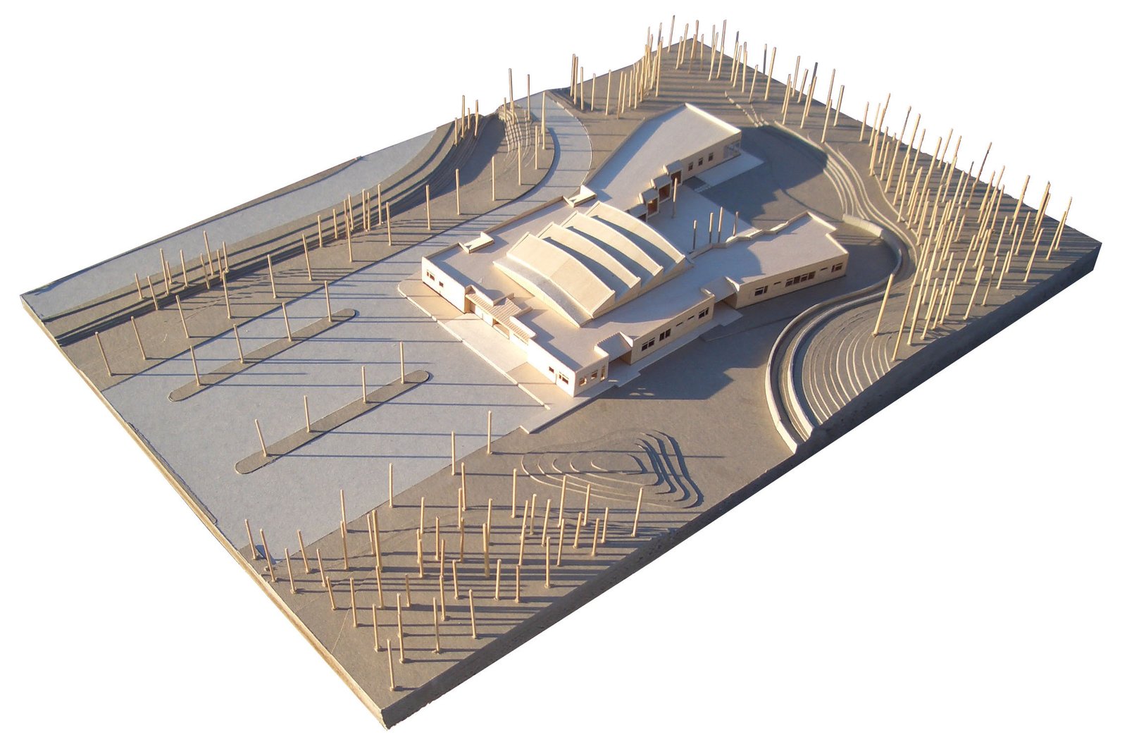 An architectural model of a school with curved roofs, pathways, and site contours.