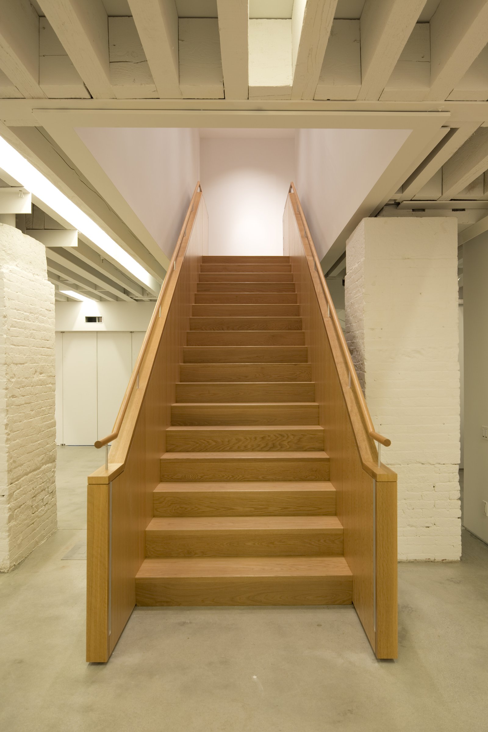 Wooden staircase with clean lines leading to upper level.