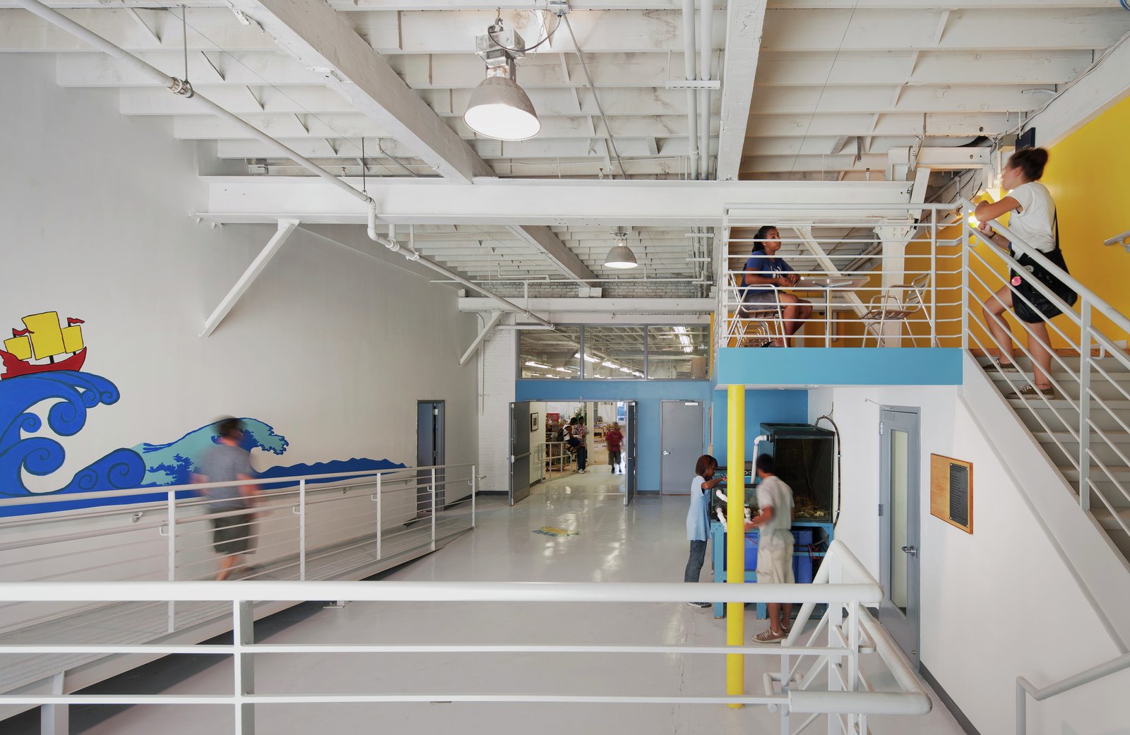 Bright, open hallway with stairs and a nautical mural on the wall.