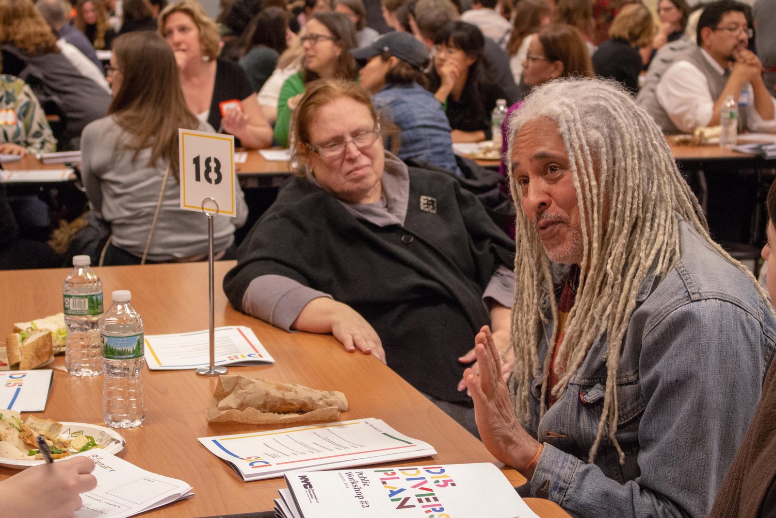 Community members participate in a workshop discussion around a table.