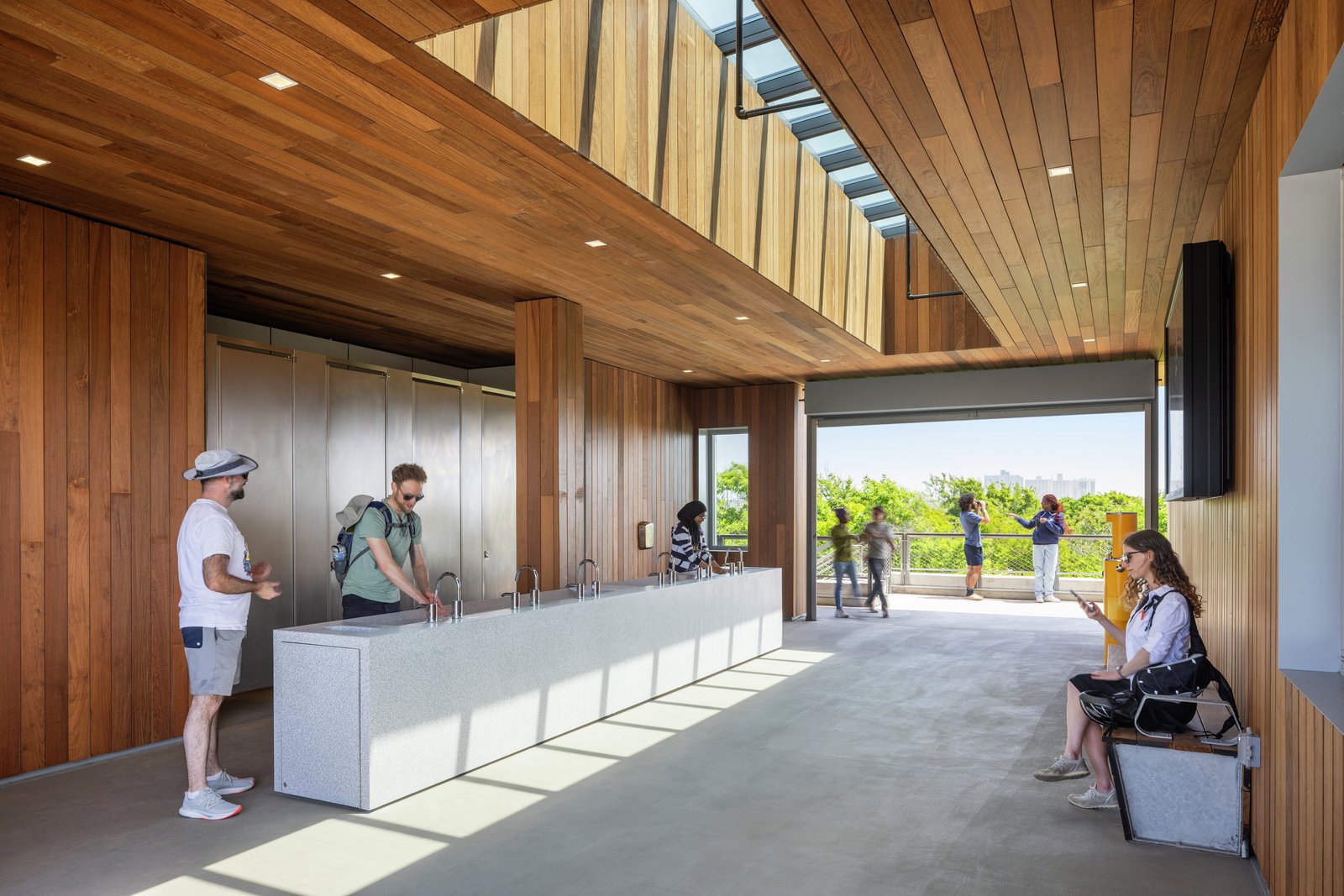 Interior of the Coastal Conservation Center with wooden walls, skylights, and people using the space.