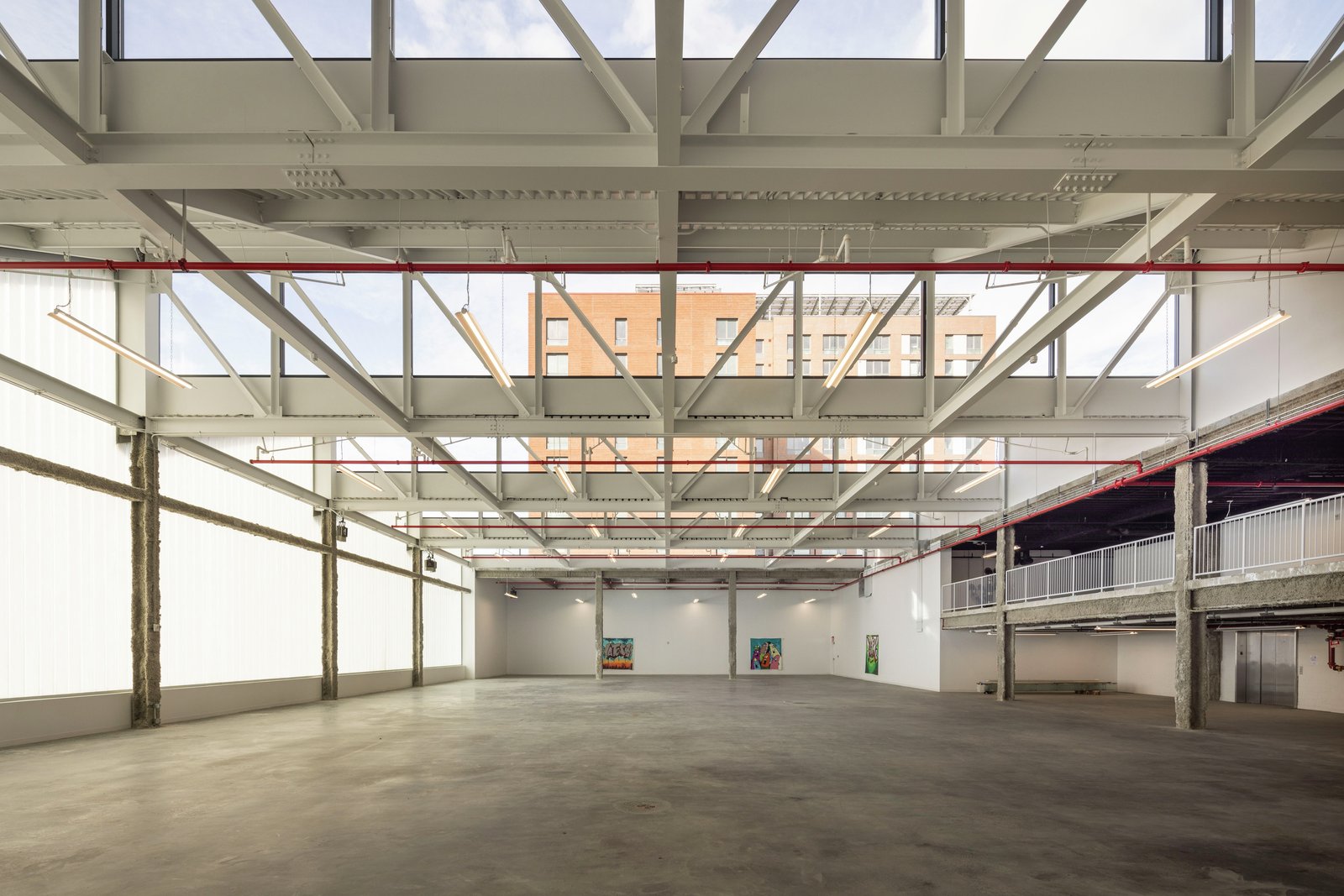 Open industrial interior with large skylights and concrete floor, surrounded by translucent walls.