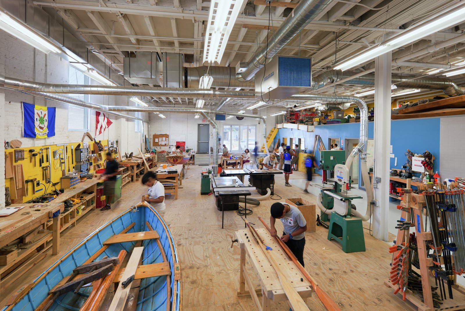 Spacious workshop with students working on various boatbuilding projects.