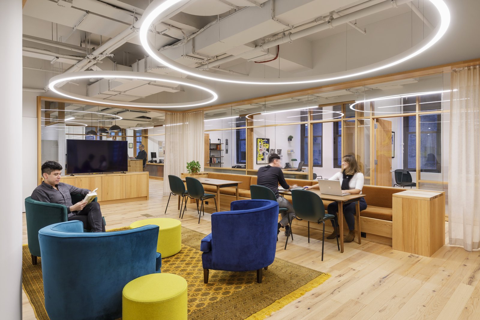 Lounge area with vibrant seating, wood finishes, and circular light fixtures.