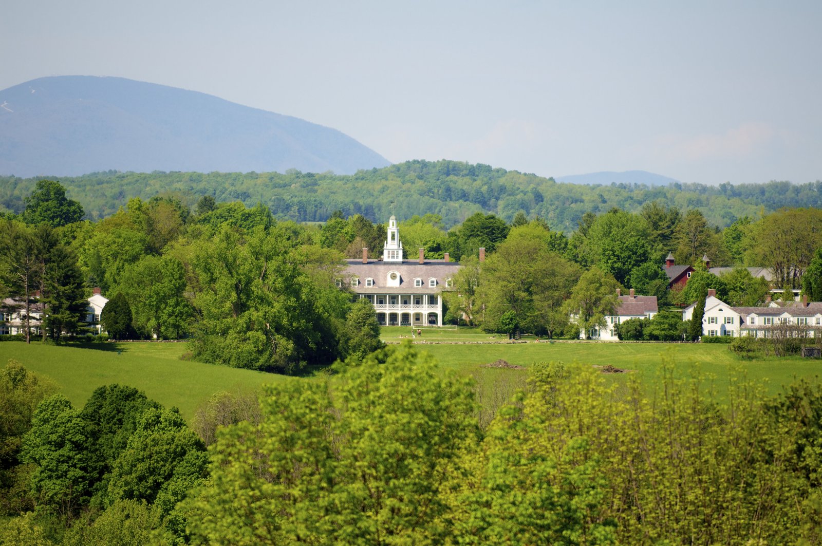 Bennington College campus surrounded by lush greenery and distant mountain views.