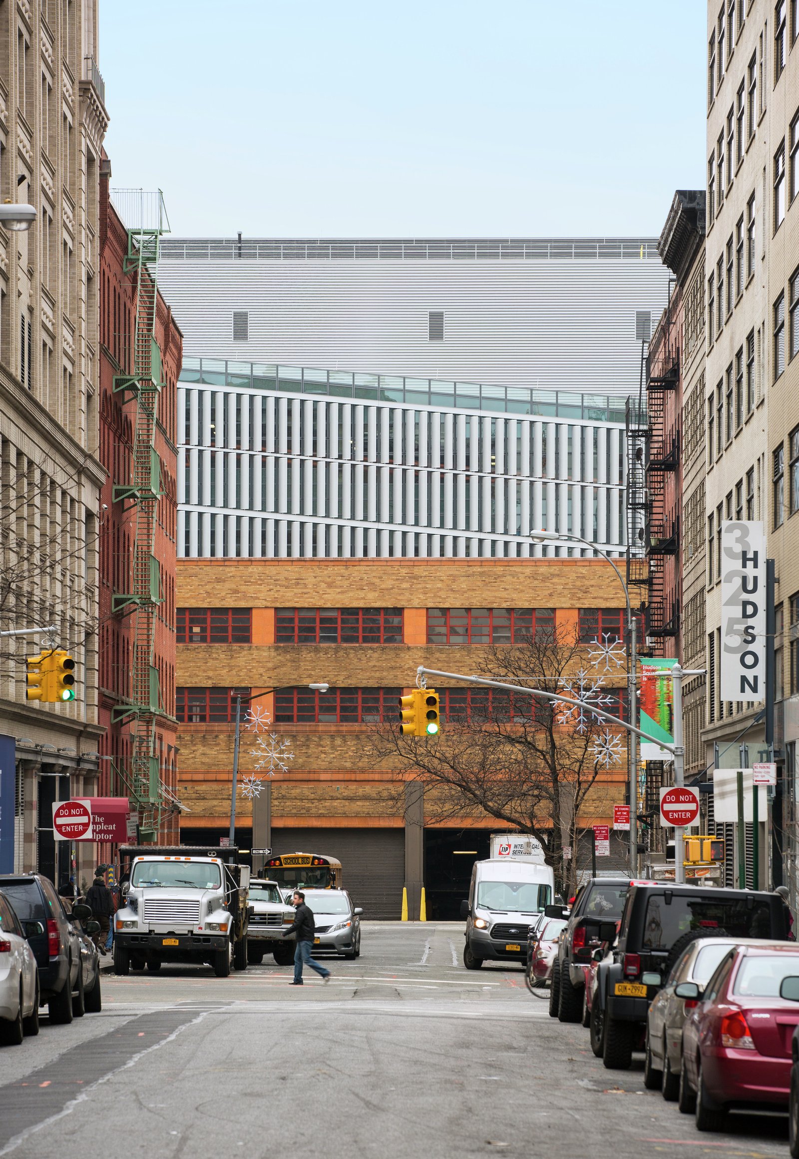 View of the DSNY Manhattan District 1/2/5 Garage, with upper levels that incorporate a rhythmic arrangement of vertical louvers and glass panels.