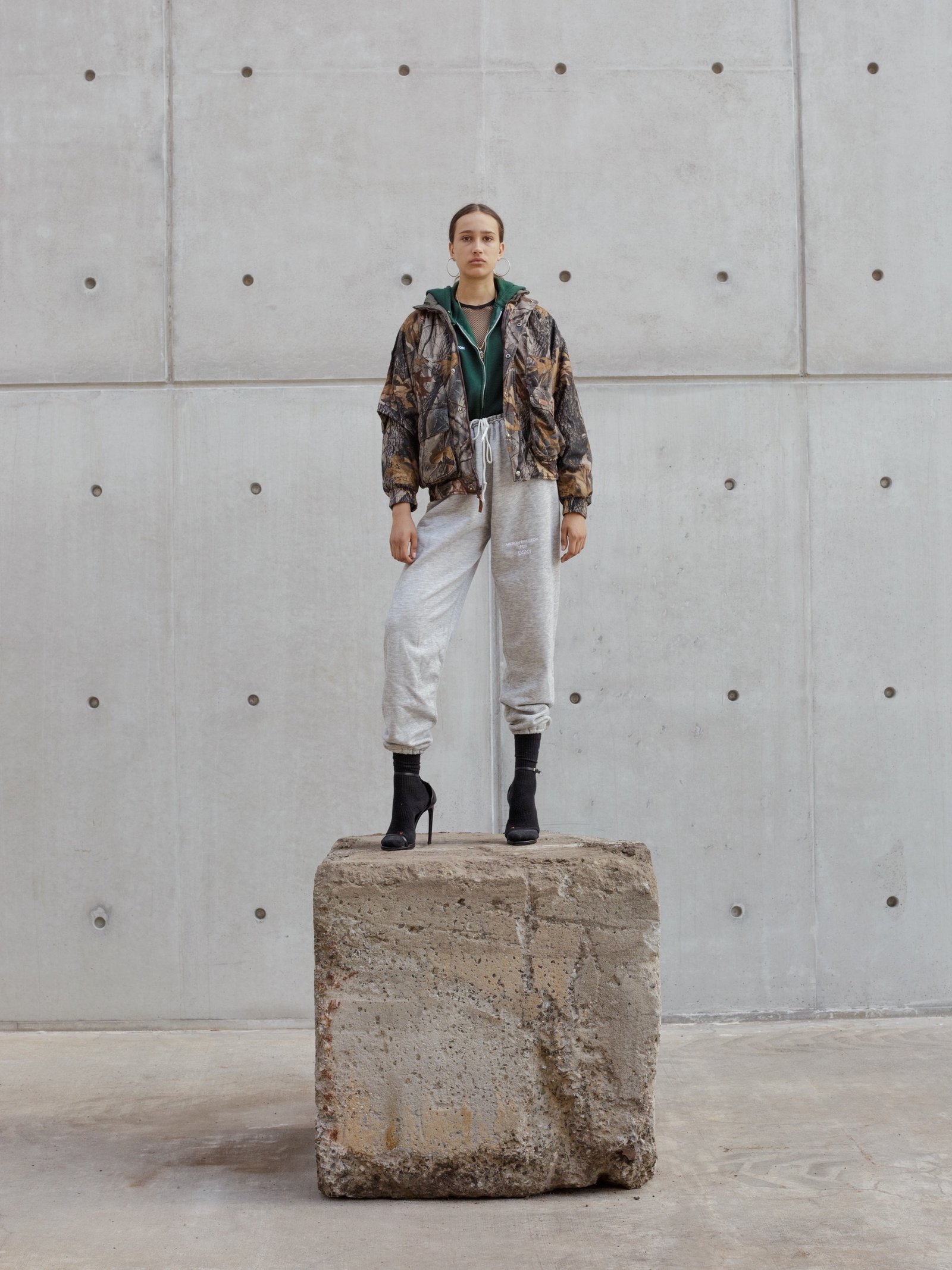 A model stands on a stone block in front of the Salt Shed.