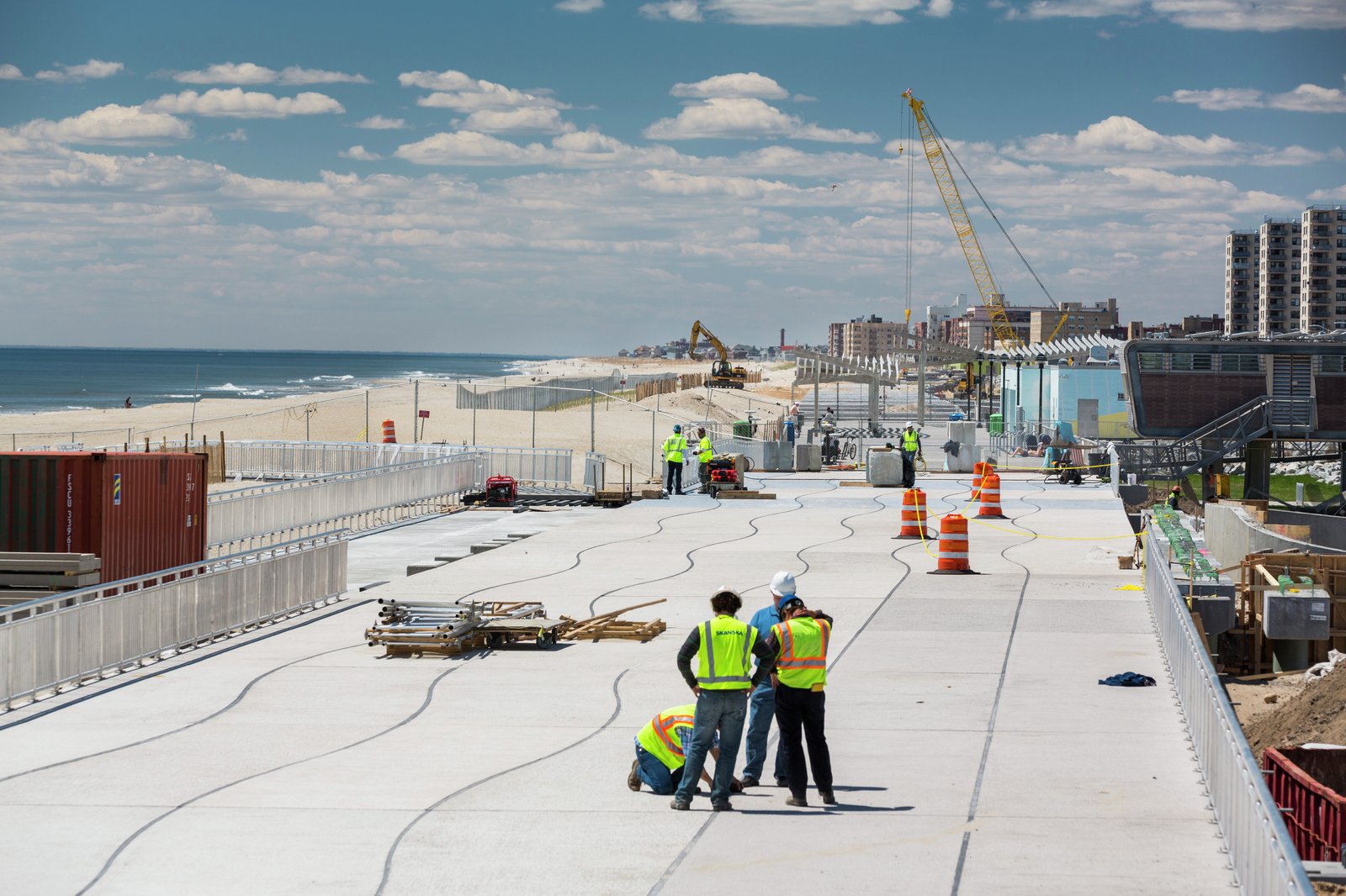 Construction on the Rockaway boardwalk rebuilds coastal resilience, with new pathways and restored ocean-facing dunes.