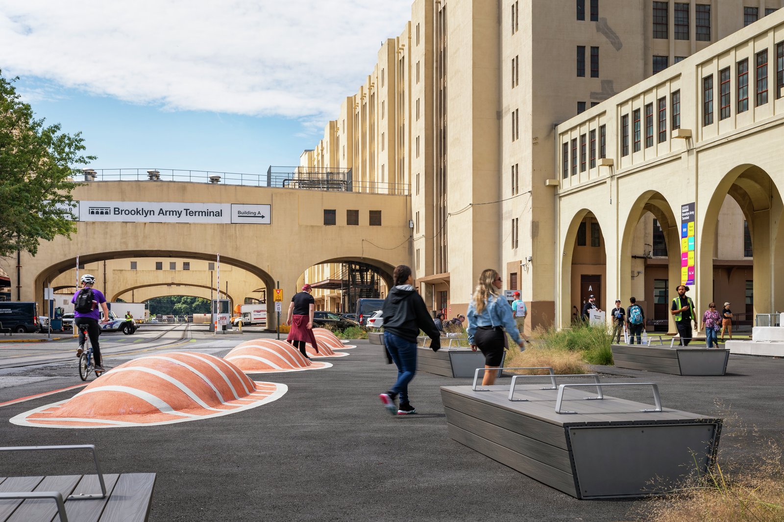 A rendering picturing striped traffic-calming berms, bike path, and seating.