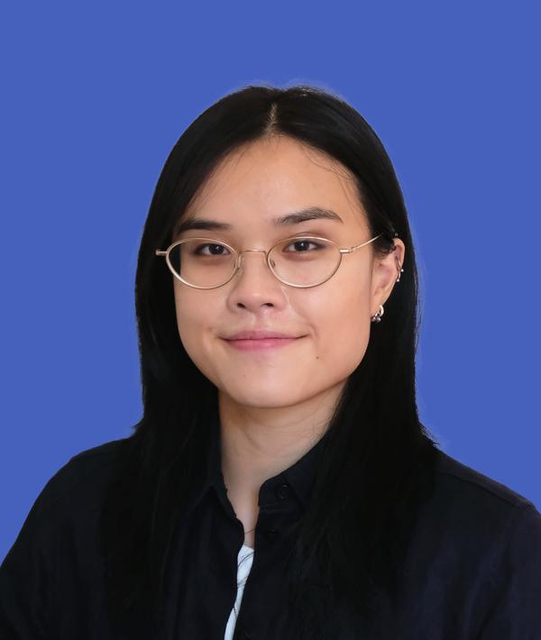 Headshot of Zoe Lin in a dark top against a blue background.