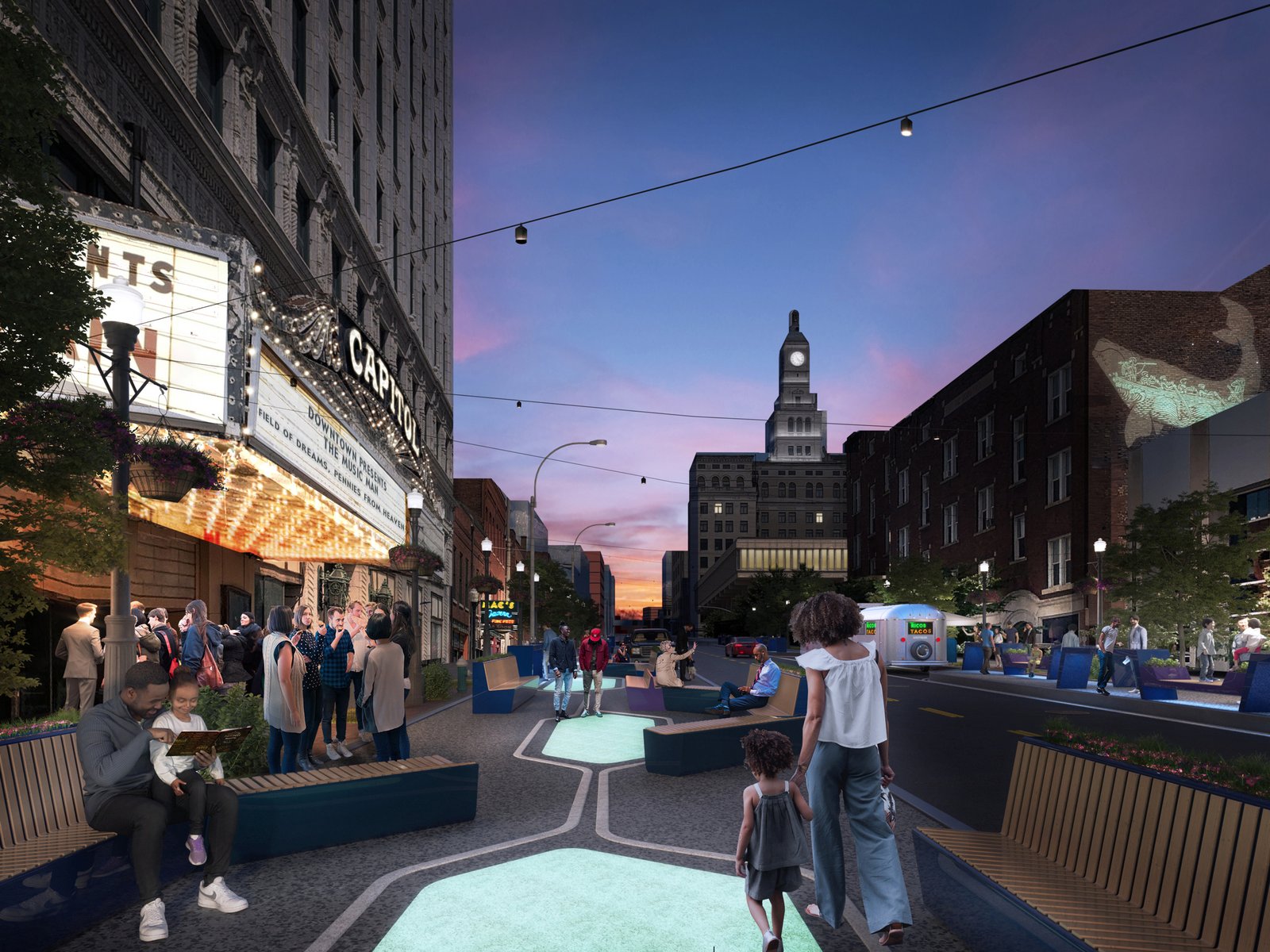 Evening view of a downtown Davenport street with public seating, lighting, and community activity.