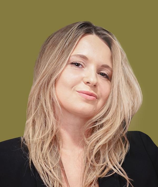 Headshot of Anna Hajdo in a dark top against a green background.